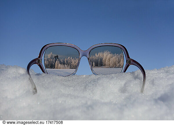 Snowy winter landscape view through sunglasses. Reflection.