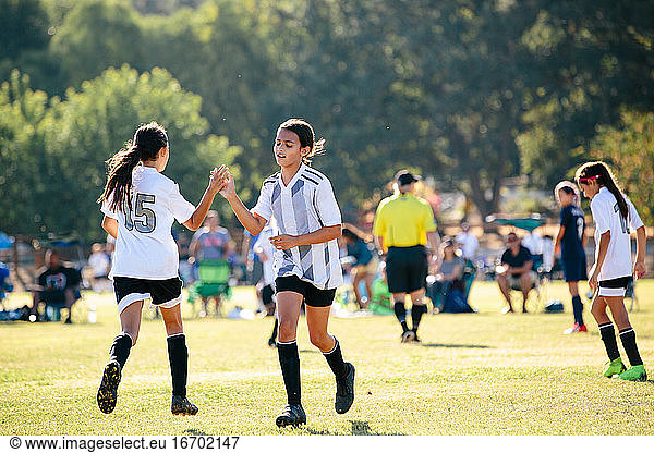 Soccer player girl gives her teammate a high five