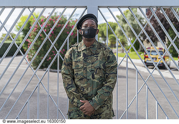 Soldat der Armee trägt einen Gesichtsschutz  während er am Tor steht