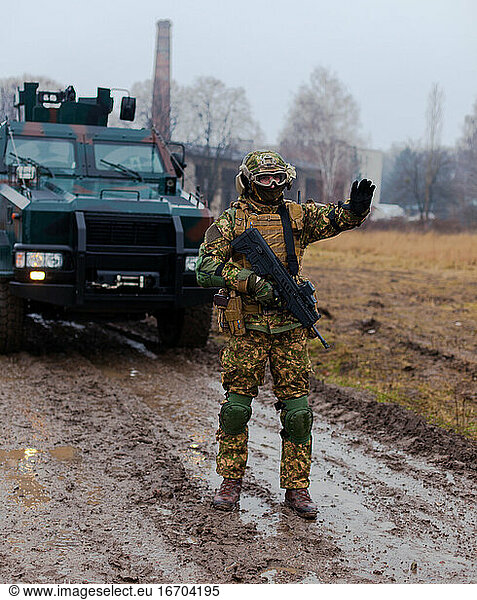 Soldat hält den Wagen mit einem Maschinengewehr in der Hand an