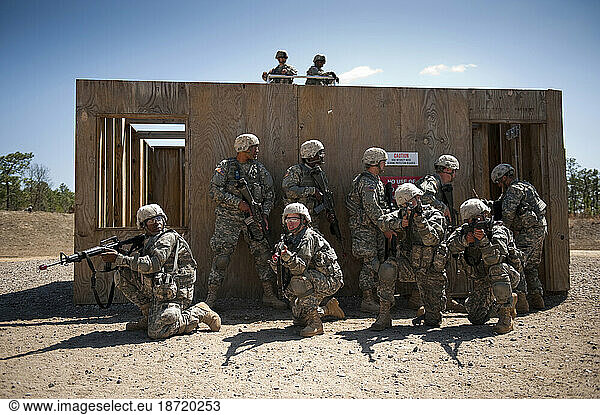 Soldiers in basic training move tactically as a squad during close quarters combat training.