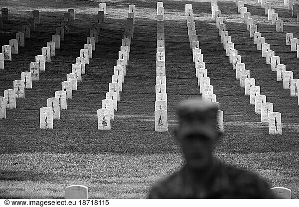 Soldiers place flags on graves at Arlington National Cemetery.