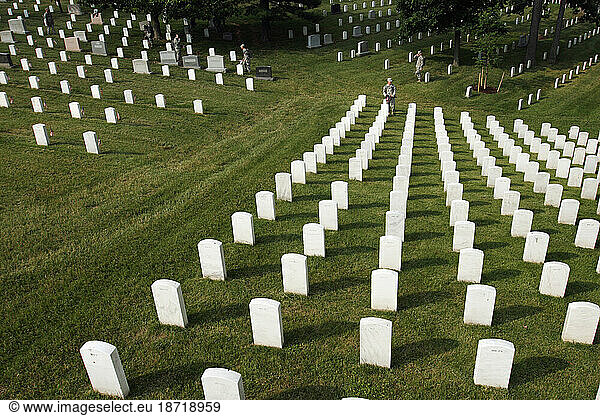 Soldiers place flags on graves at Arlington National Cemetery.