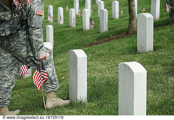 Soldiers place flags on graves at Arlington National Cemetery.