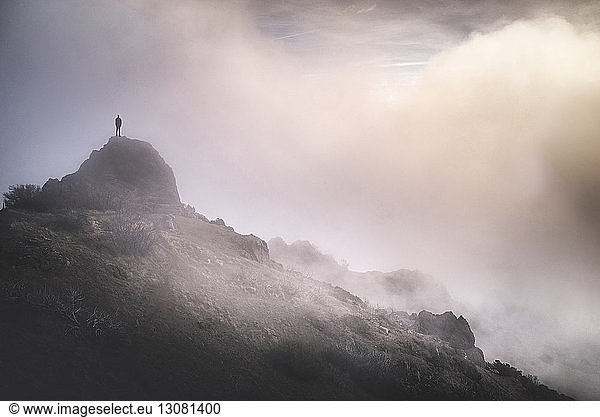 Solitude man standing on mountain during foggy weather