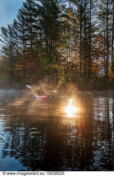 Solo paddling on a misty pond at sunrise.