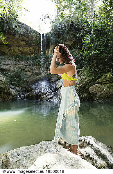 Solo Woman in a bikini with towel at a waterfall in Puerto Rico