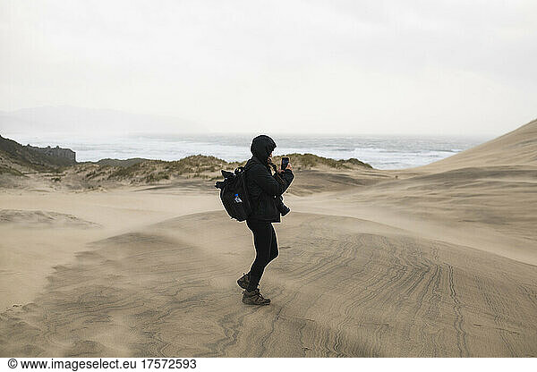 Solo Woman photographing sand dunes in coastal Oregon