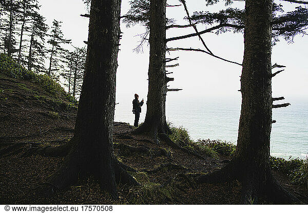 Solo Woman photographing with her phone in coastal Oregon