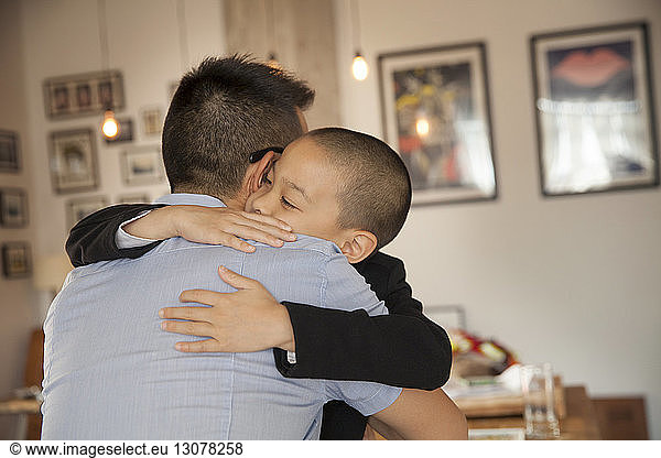 Son embracing father at home