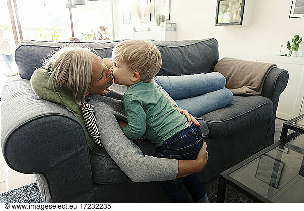Son kissing mother in living room