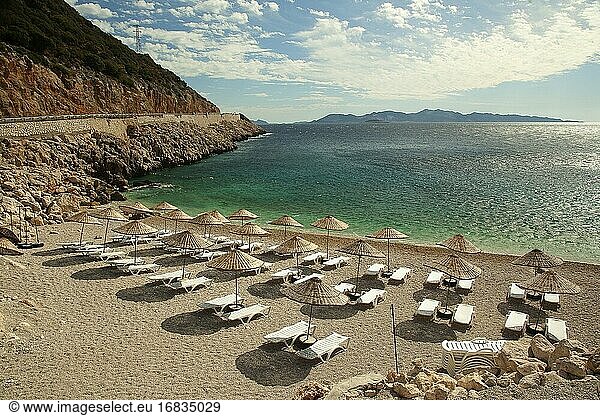 Sonnenliegen und Strohschirme an einem kleinen Sandstrand in der Nähe der Stadt Kas  Provinz Antalya  Mittelmeerküste  Region Altes Lykien  Türkische Riviera  Türkei  Europa.