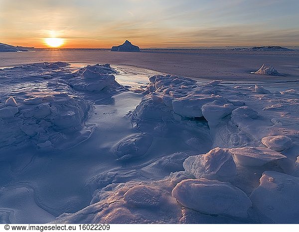 Sonnenuntergang am Ufer der zugefrorenen Diskobucht. Disko-Bucht im Winter  Westgrönland. Amerika  Nordamerika  Grönland  Dänemark