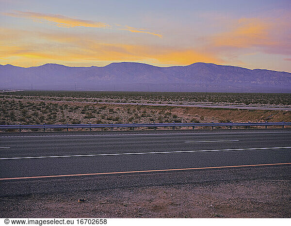 Sonnenuntergang auf einer Wüstenautobahn  östliche Sierras. Road Trip durch die Wüste.
