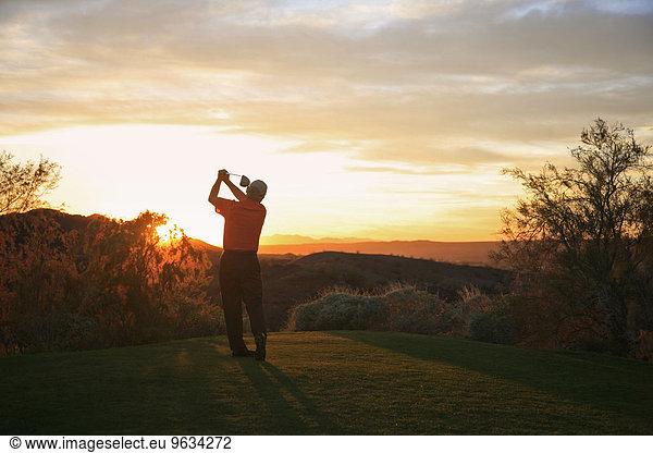 Sonnenuntergang Golfspieler Golfsport Golf Abschlag teeing off Kurs