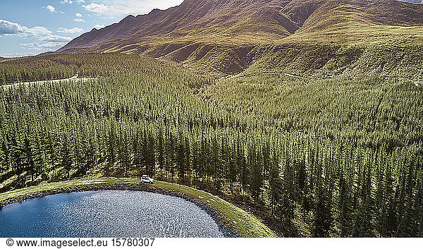 South Africa  Western Cape  Swellendam  Aerial view of 4x4 car driving along lakeshore at edge of forest