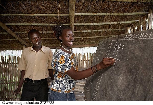 SOUTH SUDAN Loka Women´s Association Adult Literacy Klasse lehrte von einem jungen Mann  24 Jahre alte Obodia Salla Silvia Kiden eine arithmetische Summe tut
