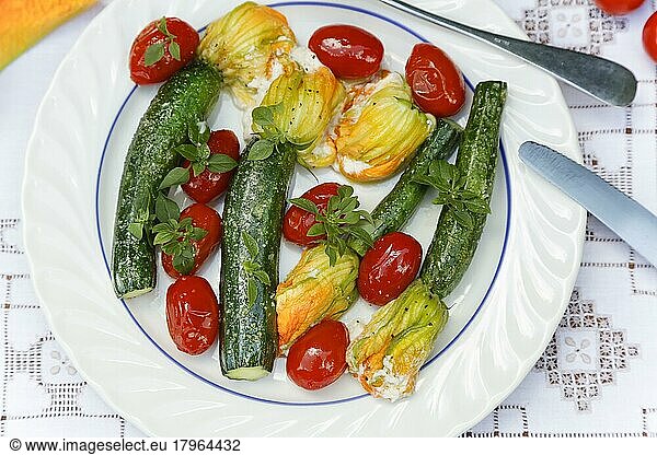 Southern German cuisine  stuffed courgette flowers sautéed on plate  cream cheese  cocktail tomatoes  cherry tomatoes  vegetarian  healthy cuisine  vegetables  cutlery  knife  tablecloth with embroidery  Germany  Europe