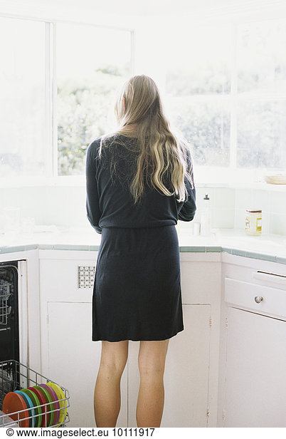 Spülbecken stehend blond Frau Küche lang langes langer lange Rückansicht Ansicht Haar