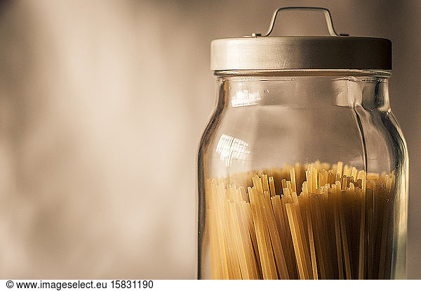Spaghetti in einem durchsichtigen Kristallglas mit grauem Metallverschluss
