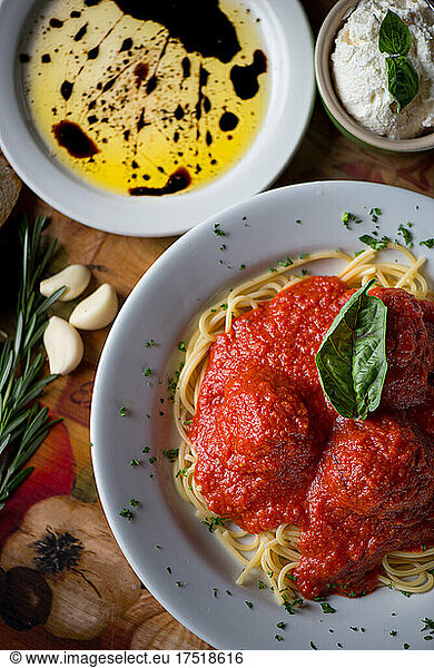 Spaghetti meatball with a basil leave ricotta cheese garlic and oil