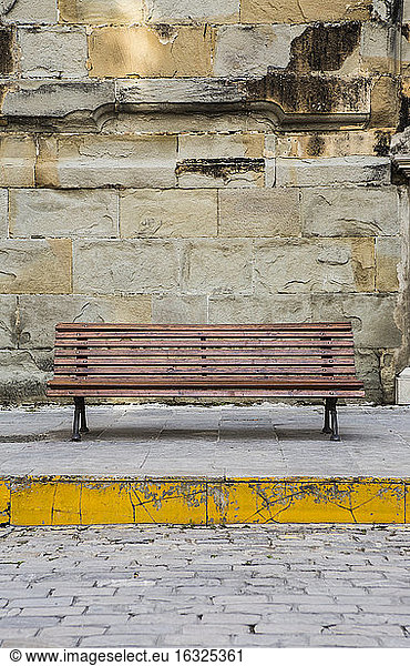 Spain  Andalusia  Tarifa  wooden bench in front of stone wall