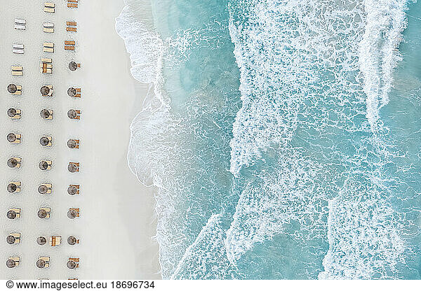 Spain  Balearic Islands  Formentera  Drone view of rows of umbrellas on empty beach
