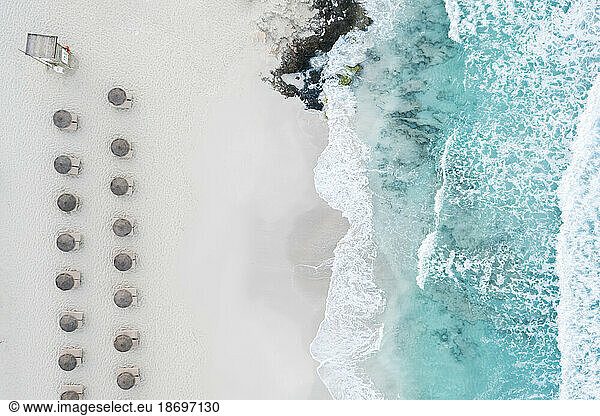 Spain  Balearic Islands  Formentera  Drone view of rows of umbrellas on empty beach