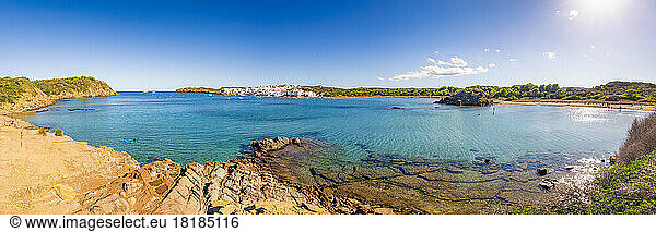 Spain  Balearic Islands  Menorca  Panoramic view of bay in summer with village in distant background