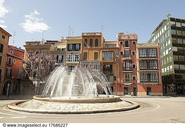 Spain  Balearic Islands  Palma  Traffic circle fountain with row houses in background