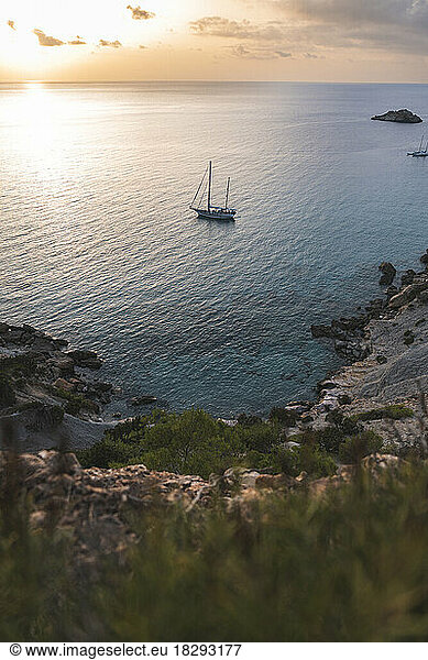 Spain  Balearic Islands  Sailboat floating near shore at sunset