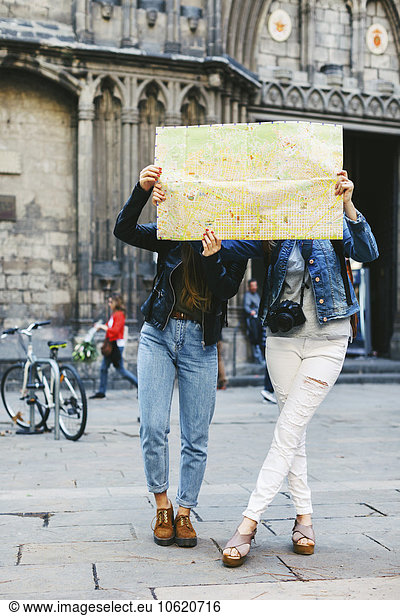 Spain  Barcelona  two young women reading map