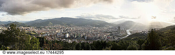 Spain  Biscay  Bilbao  Panorama of city at sunset with mountains in background