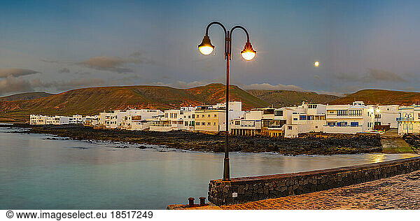 Spain  Canary Islands  Arrieta  Panoramic view of village on shore of Lanzarote island at dusk
