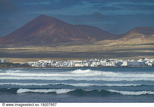 Spain  Canary Islands  Caleta de Famara  Coastal village with mountain in background
