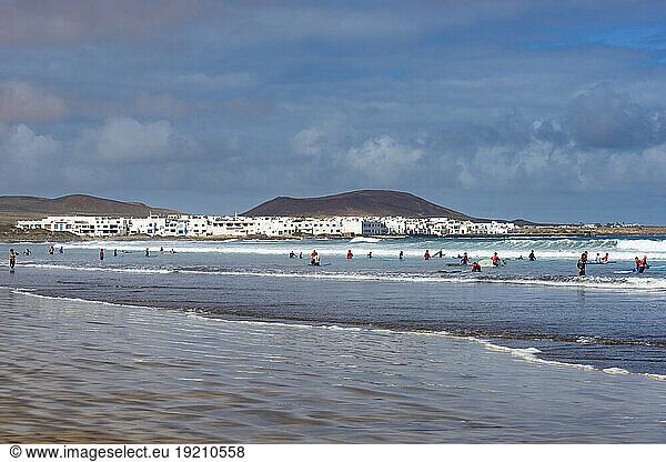 Spain  Canary Islands  Caleta de Famara  People swimming and surfing at Playa de Famara beach