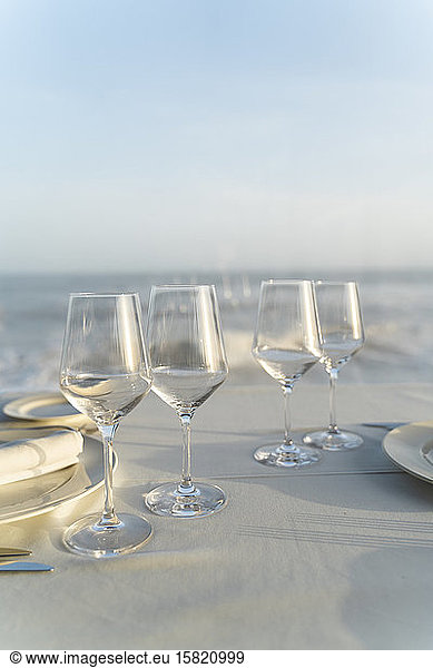 Spain  Empty wineglasses on set restaurant table with sea in background