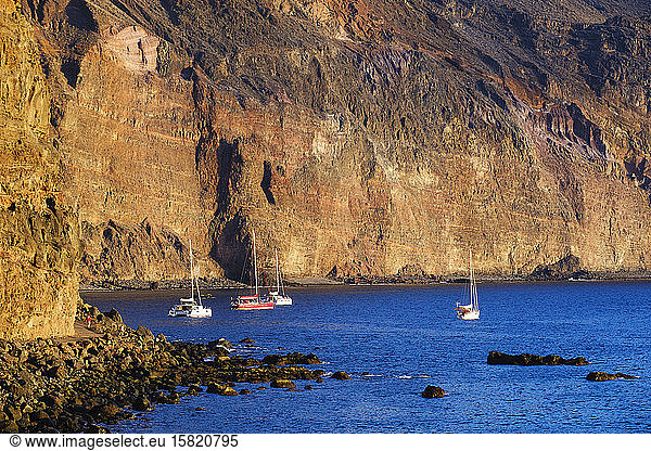 Spain  La Gomera  Valle Gran Rey  Sailboats moored in front of coastal cliff