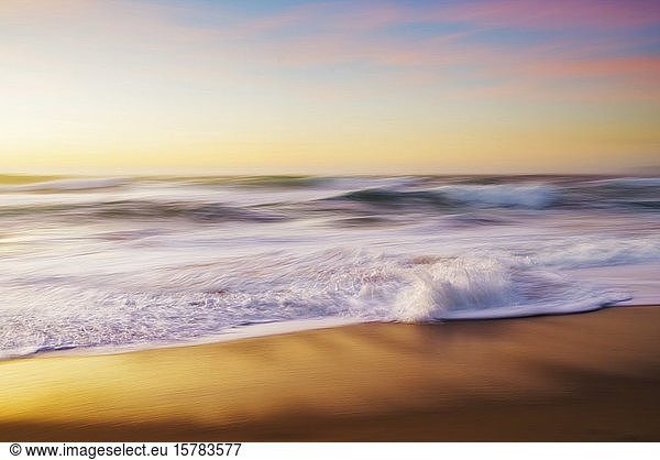 Spain  Province of A Coruna  Ferrol  Long exposure of ocean waves brushing sandy coastal beach at dusk