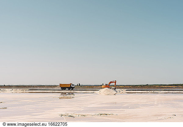 Spain  Province of Huelva  Huelva  Clear sky over truck and earth mover working in salt flat