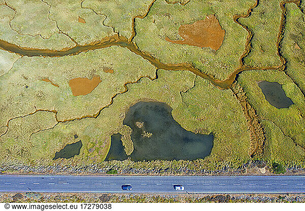 Spanien  Andalusien  Luftaufnahme einer Autobahn  die durch einen grünen Sumpf im Naturschutzgebiet Marismas del Odiel führt
