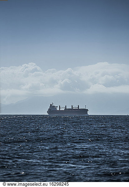 Spanien  Andalusien  Tarifa  Silhouette eines Frachtschiffs am Horizont