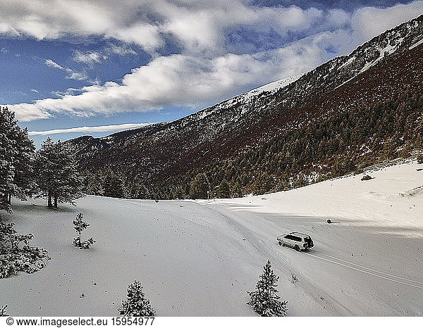 Spanien  Asturien  Cornellana  4x4-Auto fährt über ein schneebedecktes Bergtal