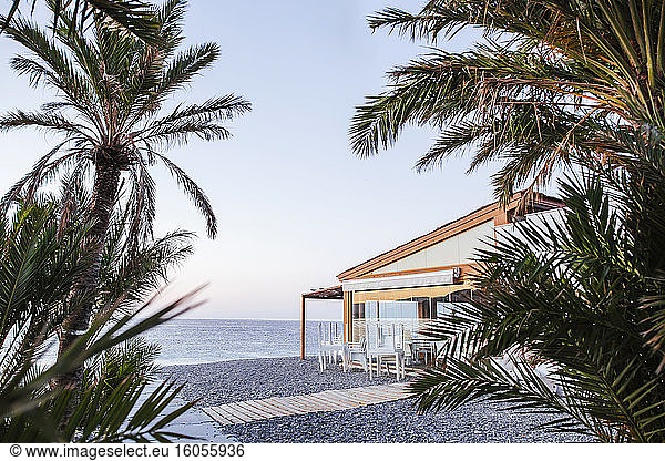 Spanien  Granada  Almunecar  Strandrestaurant mit Palmen im Vordergrund