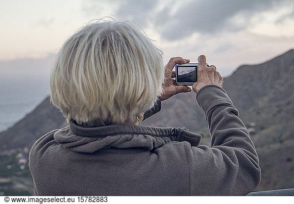 Spanien  La Gomera  Hermigua  Ältere Frau  die mit ihrer Digitalkamera fotografiert  La Gomera  Spanien