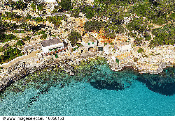 Spanien  Mallorca  Santanyi  Drohnenansicht von Bootshäusern an der felsigen Küste von Mallorca