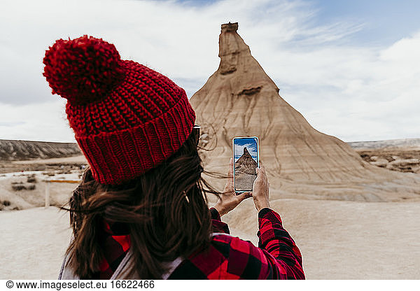 Spanien  Navarra  Touristin macht Smartphone-Fotos von Sandstein-Felsformation in Bardenas Reales