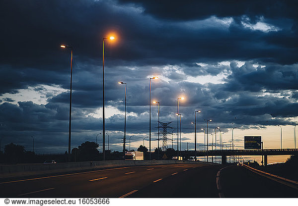 Spanien  Provinz Barcelona  Barcelona  Dunkle Gewitterwolken über der Stadtautobahn in der Abenddämmerung