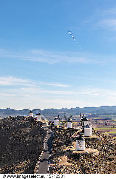 Spanien  Provinz Toledo  Consuegra  Landstraße entlang einer Reihe alter Windmühlen  die auf einem Hügel stehen