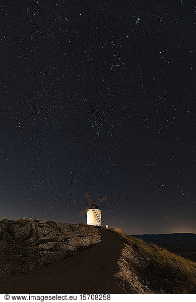 Spanien  Provinz Toledo  Consuegra  Sternenhimmel über alter Windmühle  die nachts auf einem Hügel steht